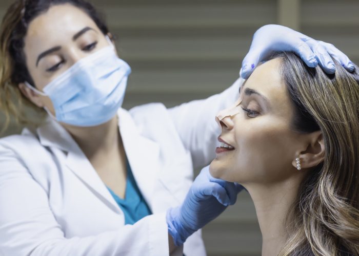 Doctor applying tape for a rhinoplasty simulation